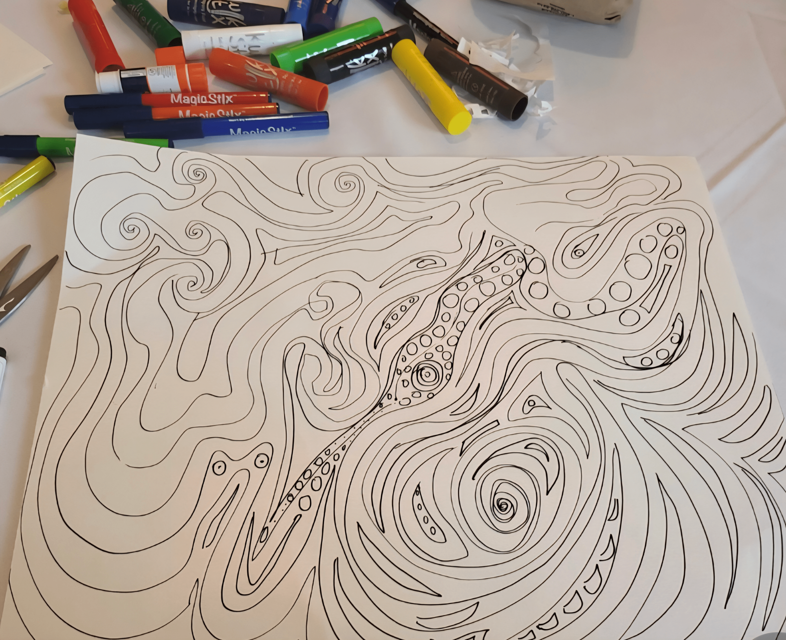 Abstract black and white line drawing featuring flowing, swirling patterns with elements resembling tentacles, surrounded by colorful markers.
