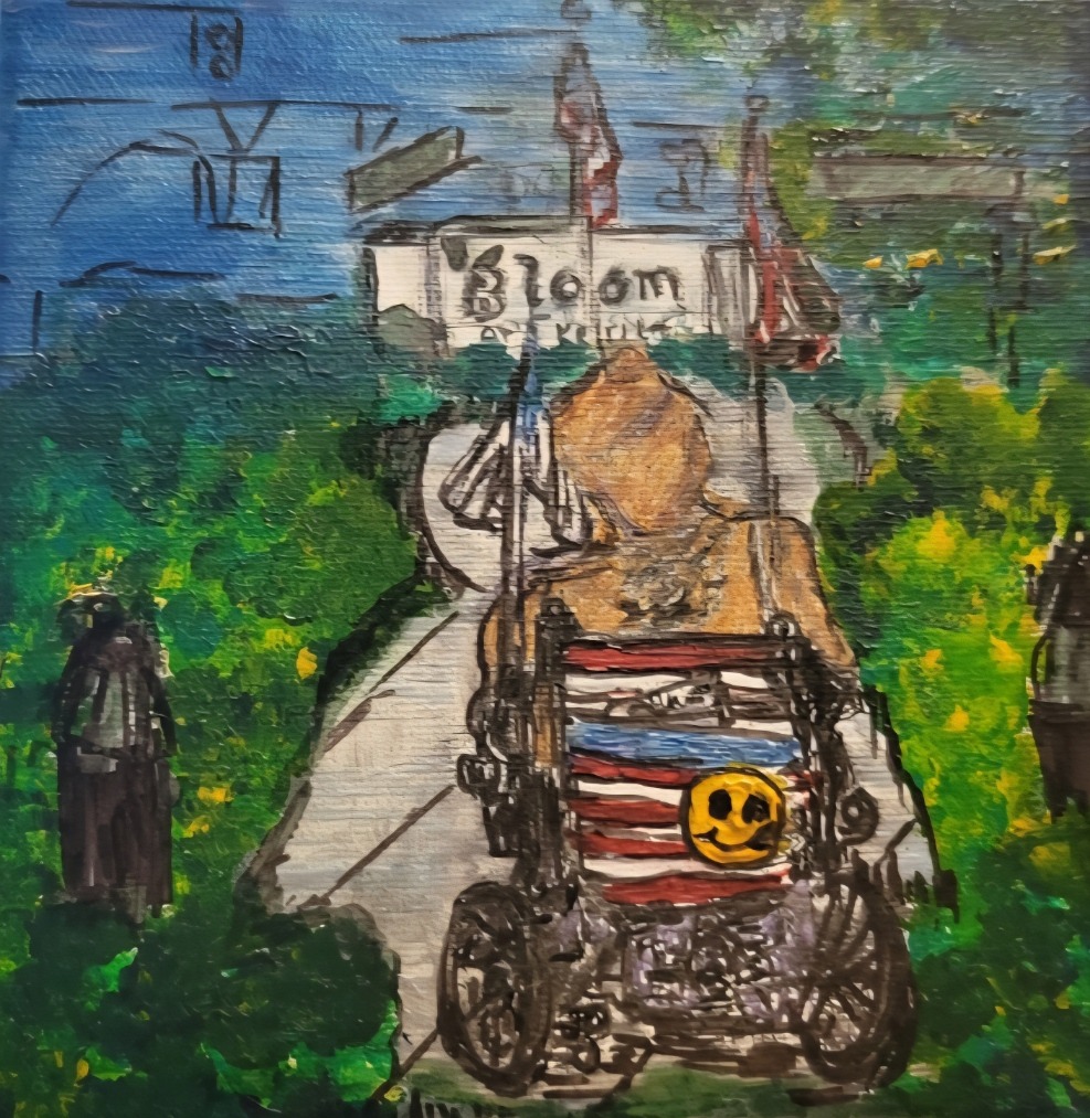 A person in a wheelchair, adorned with a smiling sticker and American flag design, faces a path leading to a building labeled "Bloom," surrounded by greenery.